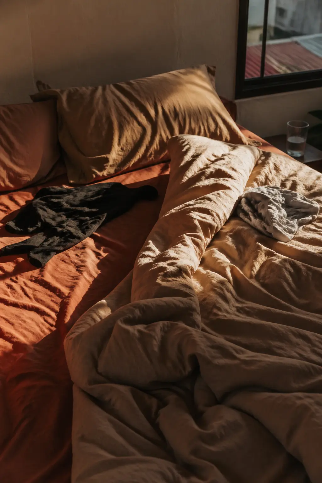 Warm linen bed in a Saigon apartment in morning light